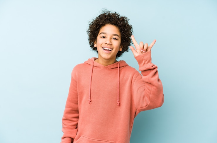 Foto menino afro-americano isolado mostrando um gesto de chifres como um conceito de revolução.