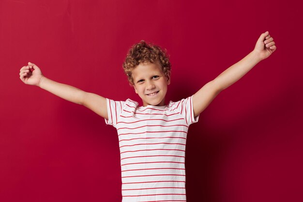 Menino alegre em roupas casuais posando gesto de emoção com as mãos