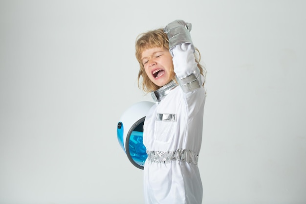 Menino animado vestindo uma fantasia de capacete de astronauta e uma criança fofa no astronauta brincando e sonhando