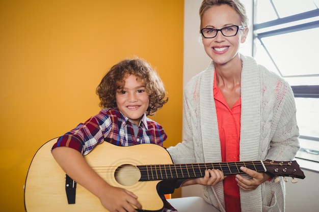 Menino aprendendo a tocar violão