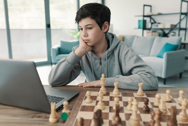 Menino aprendendo xadrez em casa