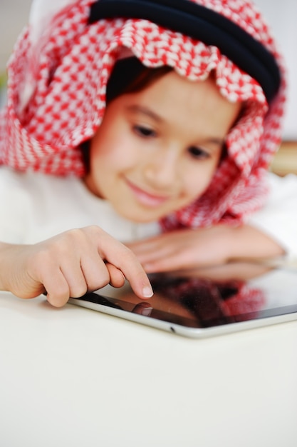 Menino árabe brincando no tablet