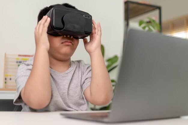 Menino asiático com óculos VR estudando ciências em casa estudante curioso usa um fone de ouvido de realidade virtual para estudar ciência em casa estudo online aprendizado estilo de vida futurista