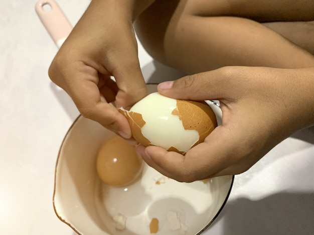 Menino asiático está descascando ovo cozido