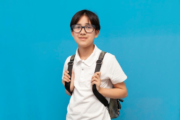 menino asiático, estudante de doze anos, usando óculos e com sorrisos de mochila