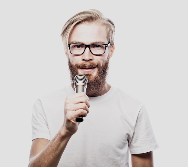 Menino balançando a imagem de um homem barbudo bonito cantando ao microfone