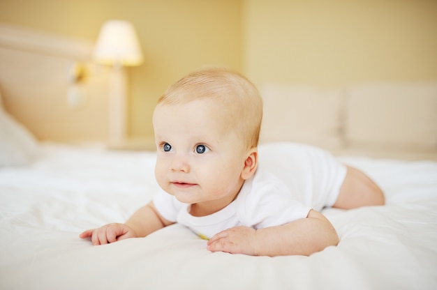 Menino bebê, rastejando, cama