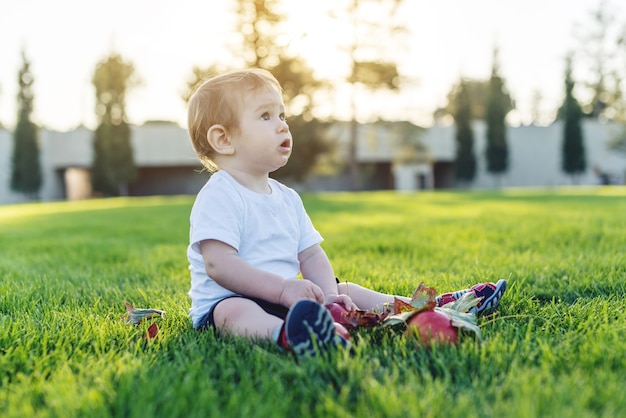 Menino bonitinho brincando com maçãs