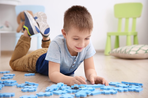 Menino bonitinho brincando com pazzles em casa