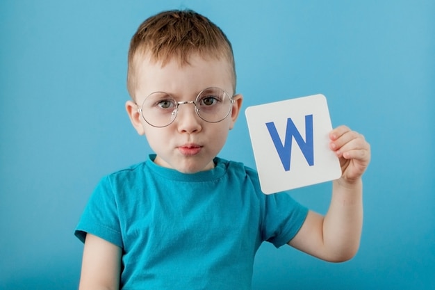 Menino bonitinho com carta. Criança aprendendo letras. Alfabeto