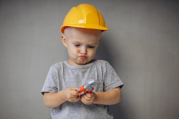 Menino bonitinho com ferramentas de construção de brinquedos