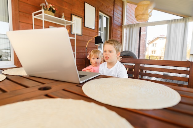 Menino bonitinho e menina usando um laptop