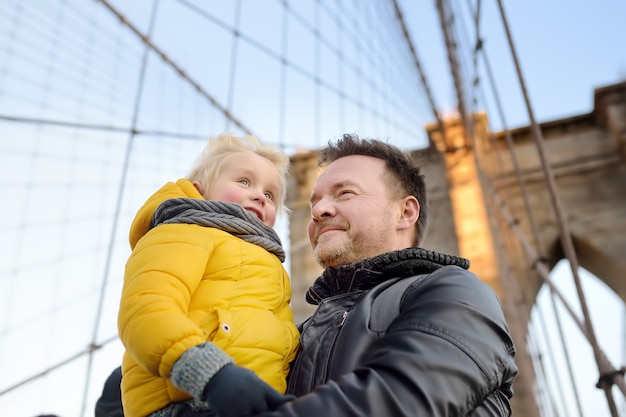 Foto menino bonitinho e seu pai na ponte de brooklyn