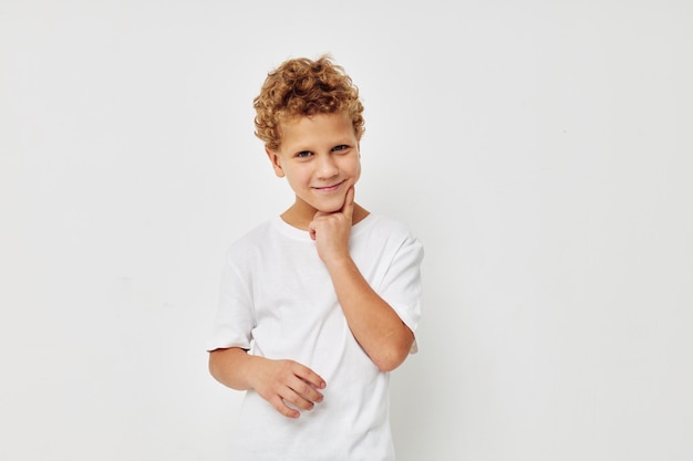 Menino bonitinho em uma camiseta branca posando fundo isolado divertido