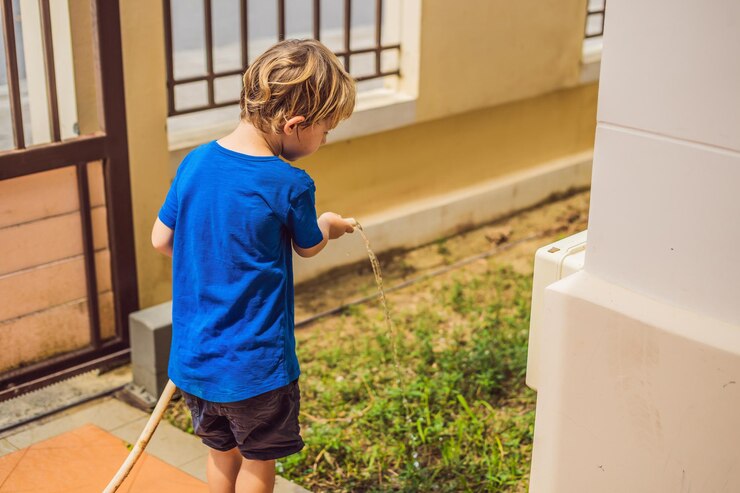 Foto menino bonitinho molhando plantas com regador no jardim adorável criança ajudando os pais a cultivar legumes e se divertindo atividades com crianças ao ar livre