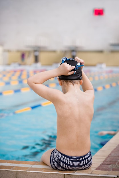 Menino bonitinho pronto para mergulhar na piscina esportiva Atividades esportivas internas para crianças