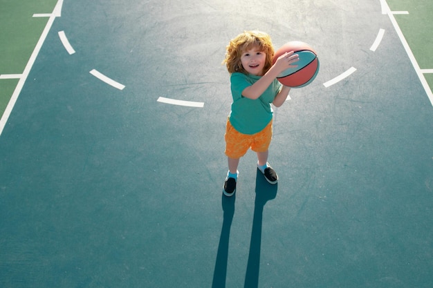 Menino bonitinho treinando basquete Escola de basquete infantil