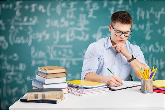 Menino bonito adolescente estudando sobre o fundo