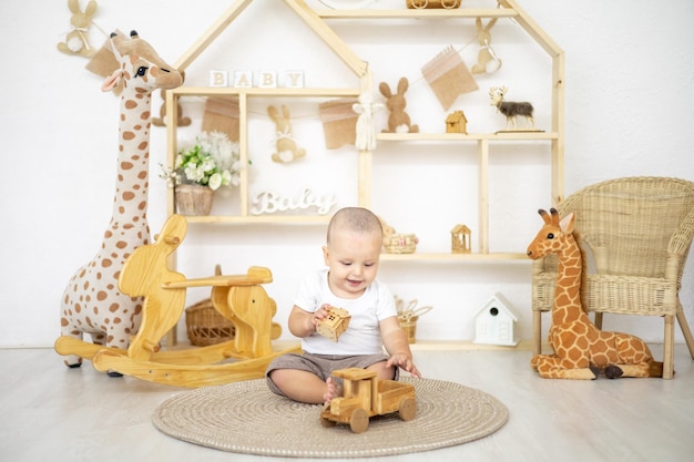 Menino bonito brincando com brinquedos naturais de madeira no quarto das crianças em casa brinquedos educativos para crianças