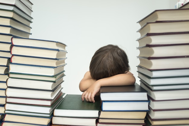 Menino bonito com muitos livros