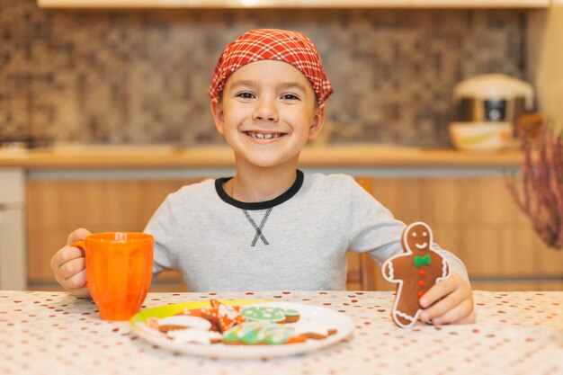 Menino bonito, comer biscoito de homem de gengibre