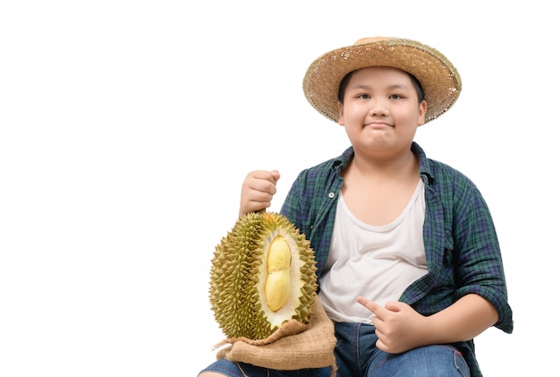 Menino bonito fazendeiro com uma fruta durian