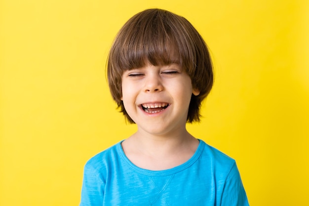 Menino bonito no espaço de banner de fundo amarelo de camisa azul para texto