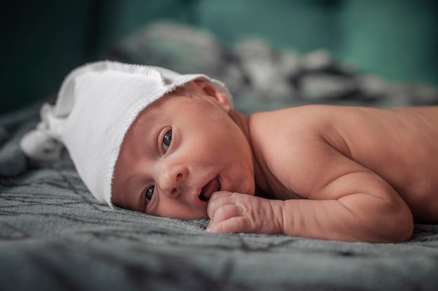 Menino bonito recém-nascido encontra-se na cama