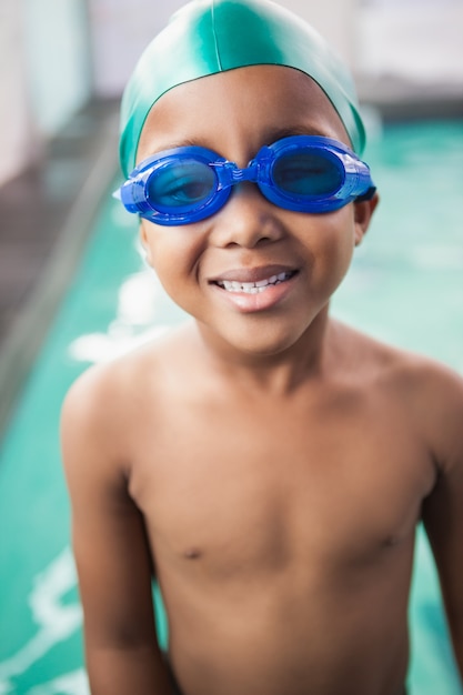 Menino bonito sorrindo para a piscina