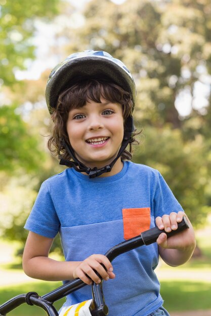 Menino bonito vestindo capacete de bicicleta