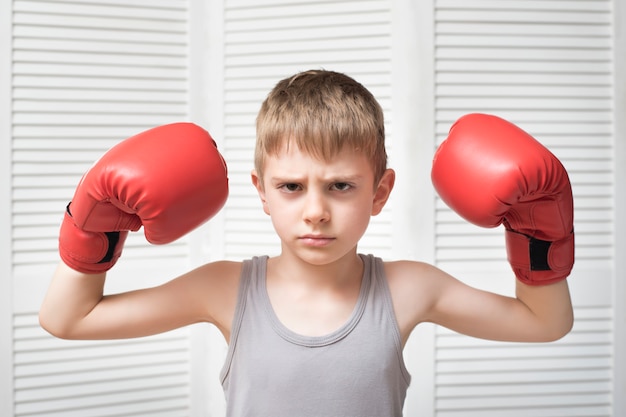 Menino bravo em luvas de boxe vermelhas.