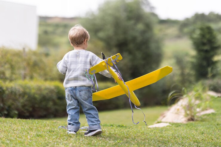 Foto menino brinca com avião de brinquedo no parque