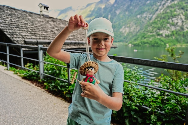 Menino brinca com boneca de brinquedo de madeira em Hallstatt Áustria