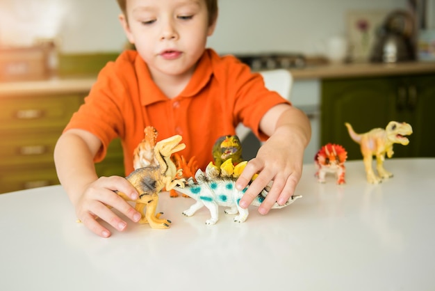 Menino brincando com dinossauros. coleção de lagartos