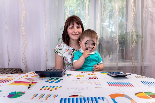 Menino brincando com lupa no escritório do analista