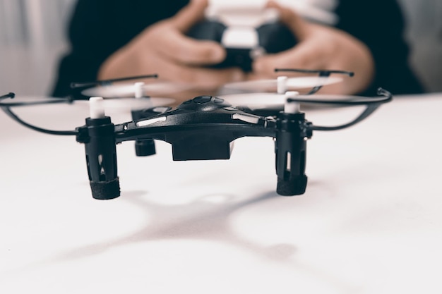 Menino brincando com um pequeno close-up do drone quadrocopter.