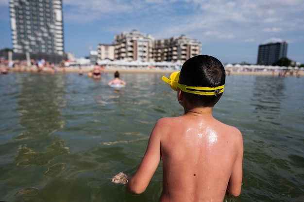 Menino brincando na água na praia