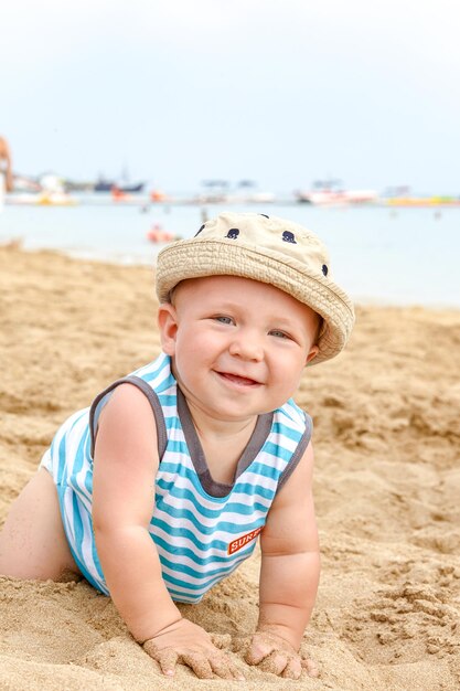 Menino brincando na areia e ondas na praia