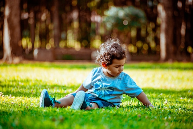 Menino brincando na grama de um parque