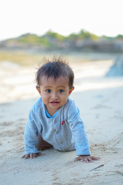 menino brincando na praia de areia de verão perto do mar.