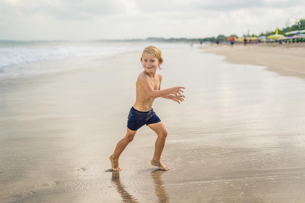 Menino brincando na praia na água