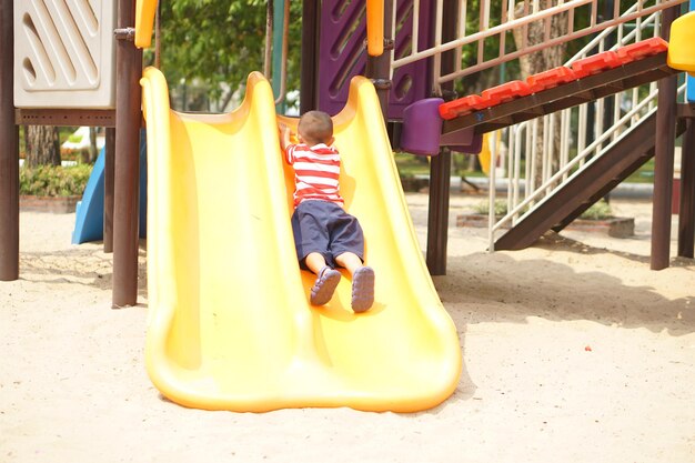 Menino brincando no playground do parque