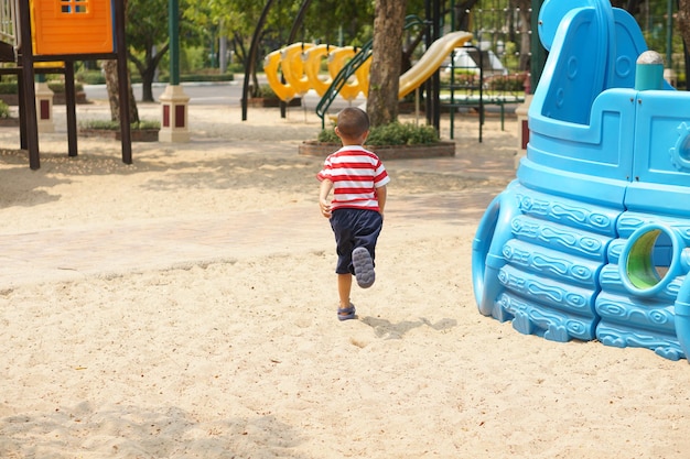 Menino brincando no playground do parque