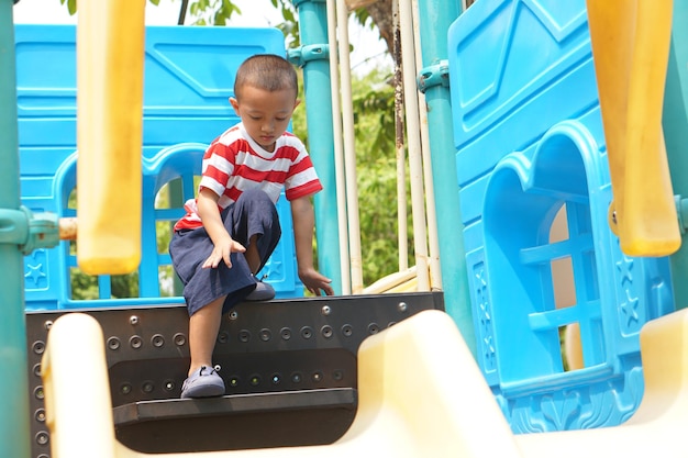 Menino brincando no playground do parque