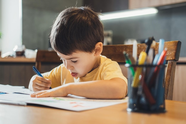 Menino caucasiano aprendendo alfabeto menino escrevendo estilo de vida de quarentena de lição de casa