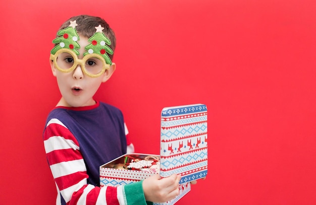 Menino caucasiano no fundo vermelho do Natal