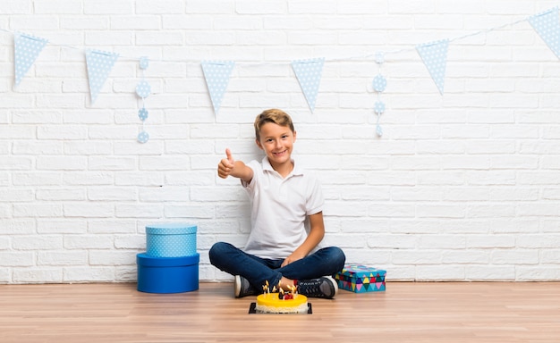 Menino, celebrando, seu, aniversário, com, um, bolo, dar, um, polegares cima, gesto, e, sorrindo