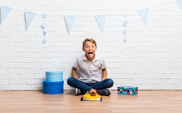 Menino, celebrando, seu, aniversário, com, um, bolo, mostrando, língua, câmera, tendo, engraçado, olhar