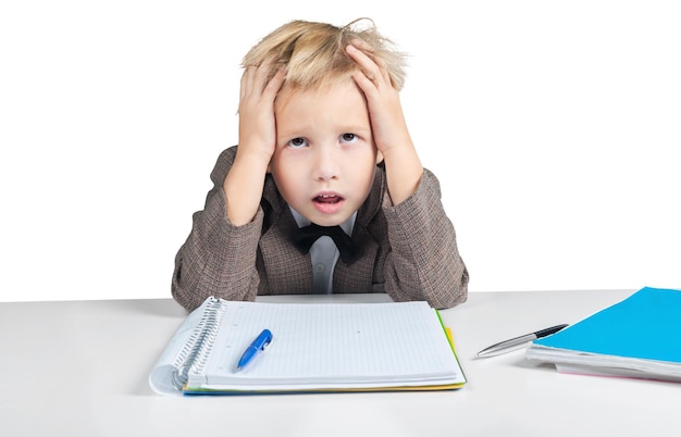 Menino chato e cansado com o bloco de notas em branco