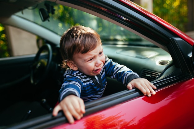 Menino chorando no carro.